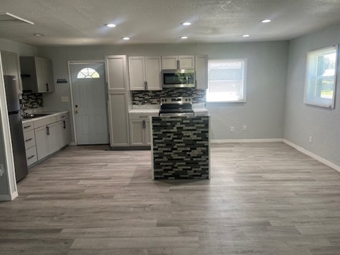 A kitchen with a stone countertop and wooden flooring.