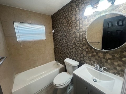A bathroom with a toilet, sink, and bathtub.