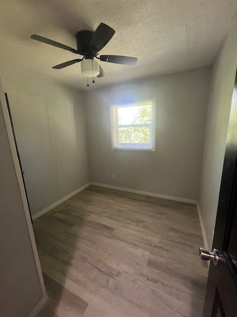 A room with a ceiling fan and a window.