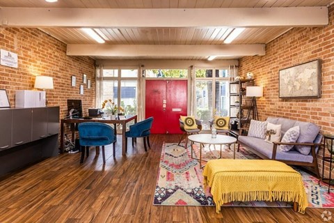 a living room with a brick wall and a red door