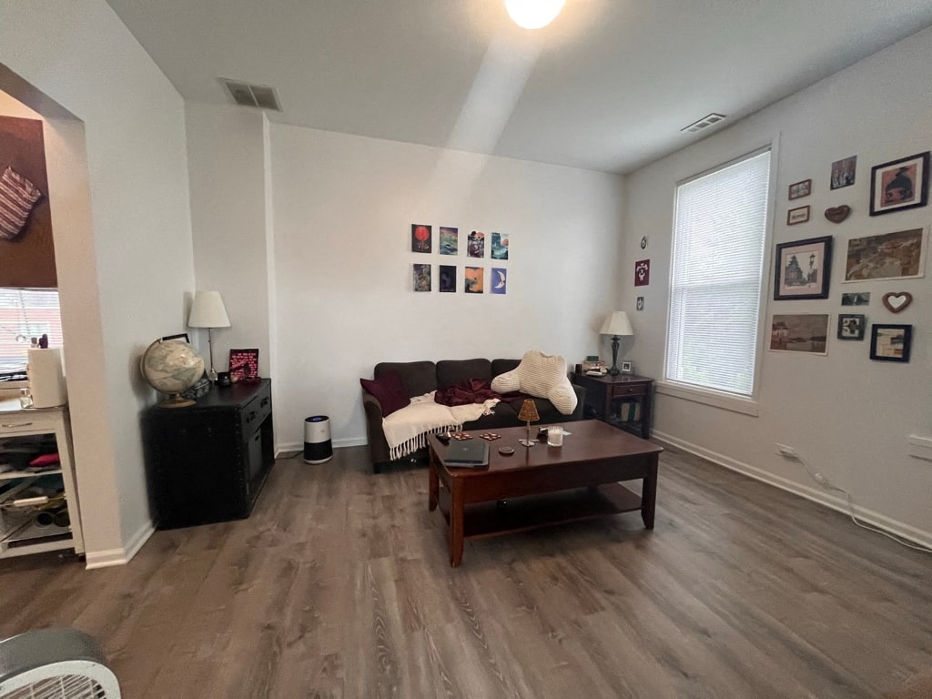 A living room with a couch, a coffee table, and pictures on the wall.