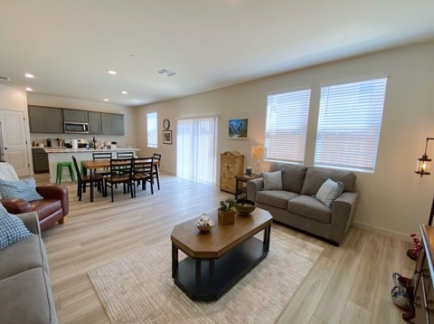 A living room with a brown leather chair and a grey couch.