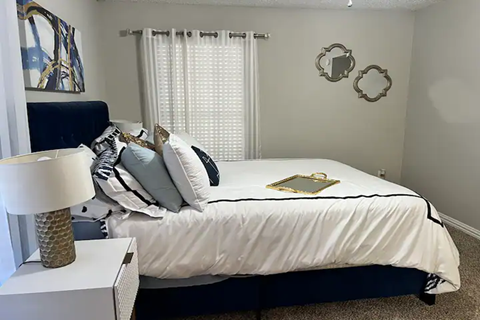 a bedroom with a bed with white sheets and pillows