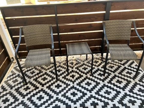 a black and white rug with two chairs and a table