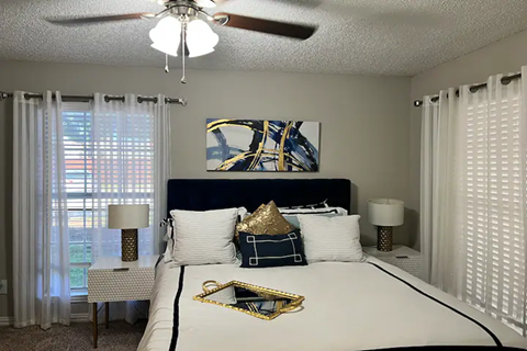 a bedroom with a large bed and a ceiling fan