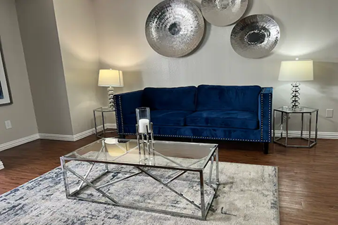 a living room with a blue couch and a glass coffee table