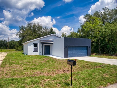 A modern house with a grey exterior and a blue garage door.