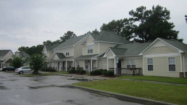 a row of houses with cars parked in a parking lot