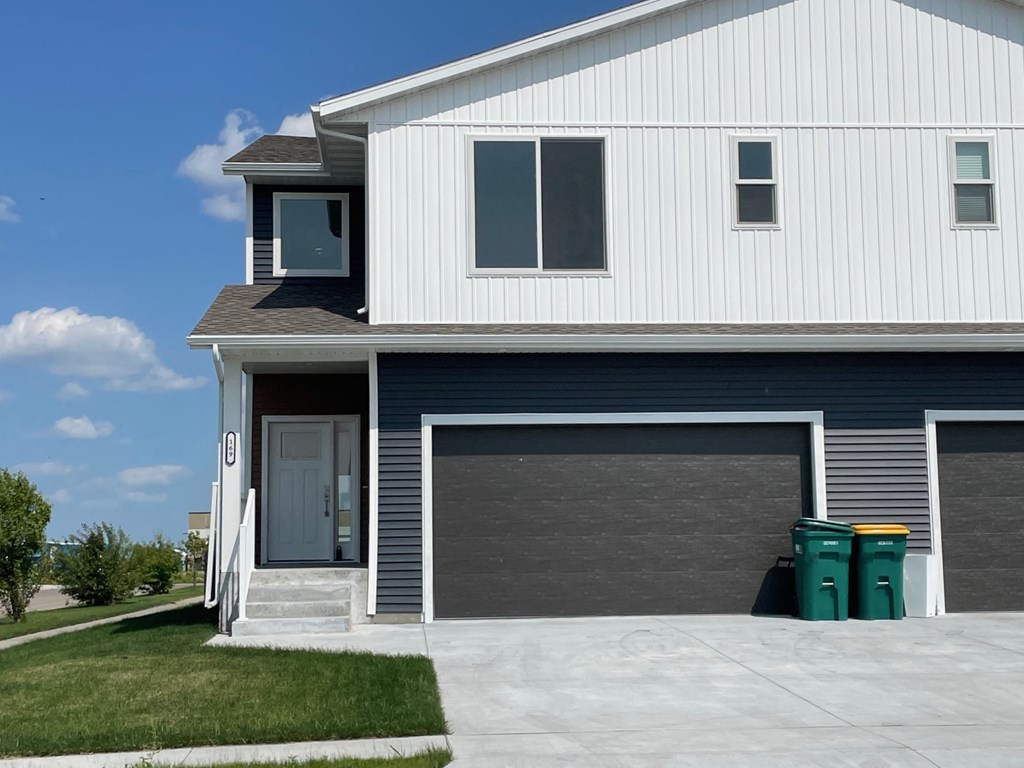 a blue and white house with a driveway and a garage door
