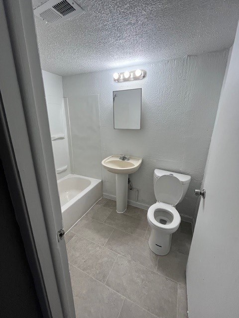A white toilet and sink in a small bathroom.