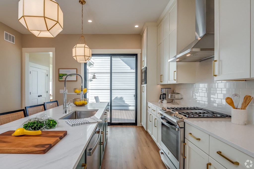 A kitchen with a wooden cutting board on the counter.