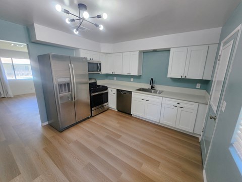 a renovated kitchen with stainless steel appliances and white cabinets