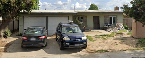 Two cars are parked in front of a garage.