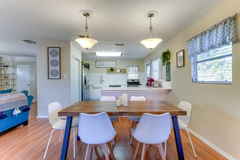 a dining room and kitchen with a table and chairs