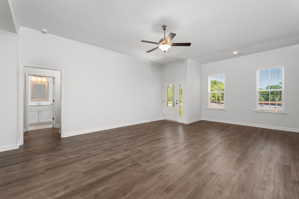 an empty living room with white walls and a ceiling fan