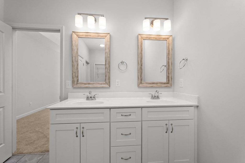 a white bathroom with two mirrors and two sinks