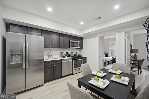 a kitchen with stainless steel appliances and a dining table
