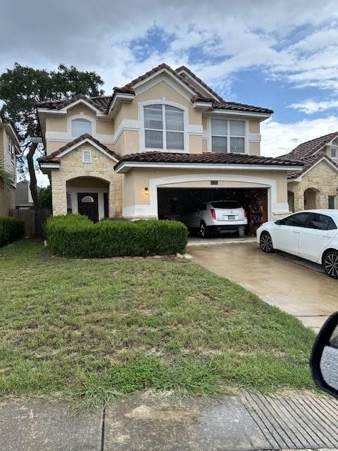 A two-story house with a garage and a white car parked in front.