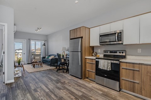 A modern kitchen with a refrigerator, oven, and microwave.