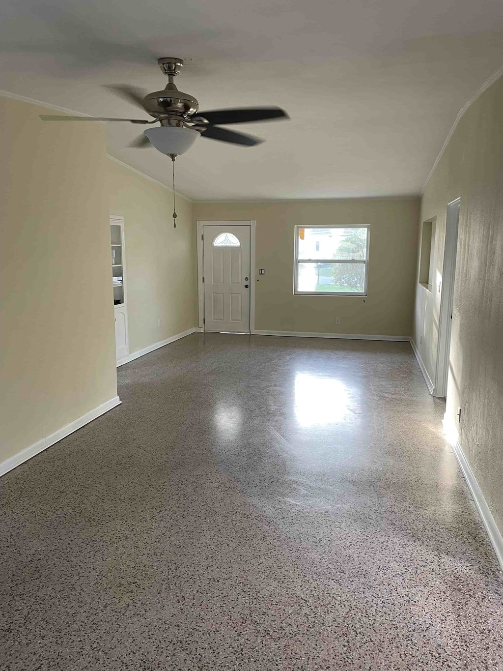 A room with a ceiling fan and a door.
