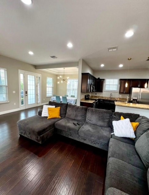 A modern living room with a grey sofa and wooden flooring.