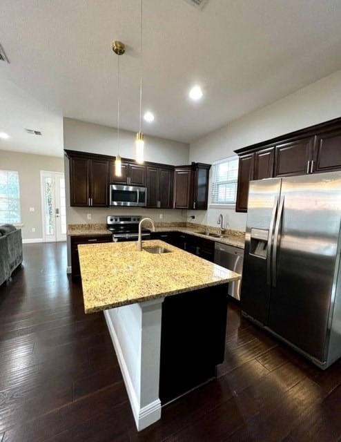A kitchen with dark wood cabinets and a granite countertop.