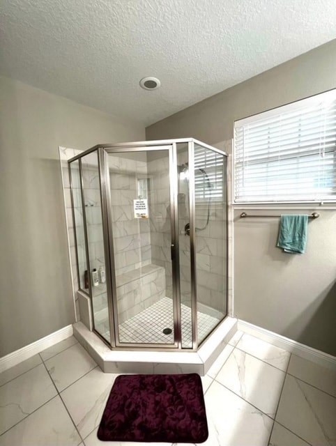 A shower stall with a glass door is in a bathroom.