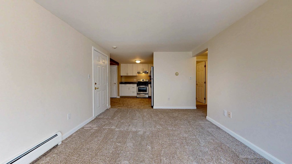 A long, empty hallway with a carpeted floor and white walls.