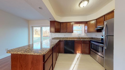A kitchen with wooden cabinets and granite countertops.