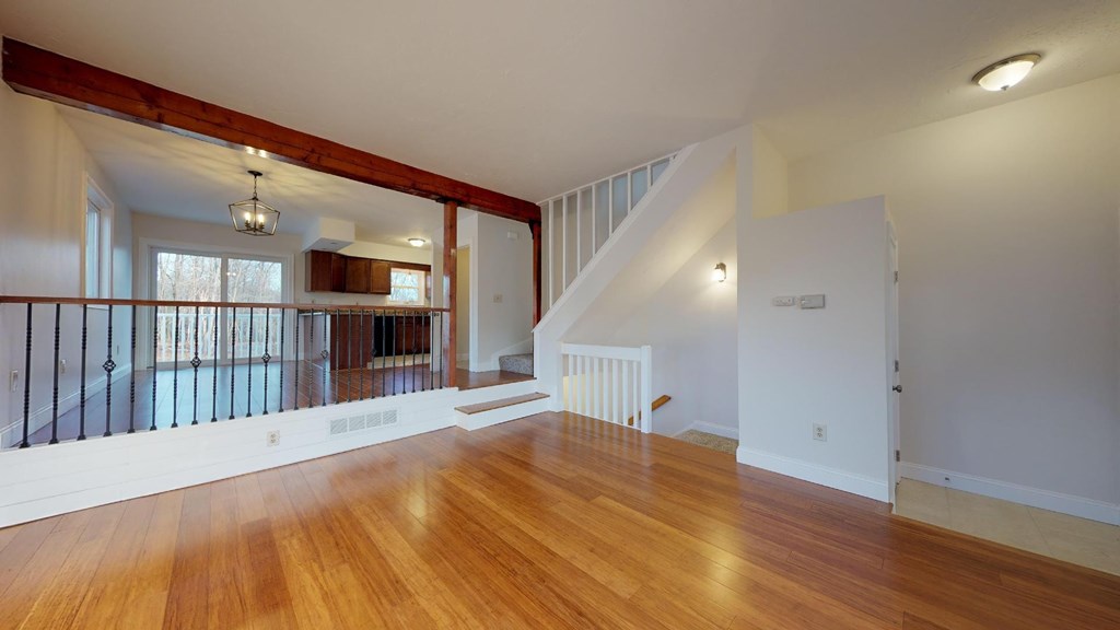 A large open room with wooden floors and a staircase.
