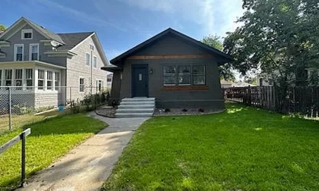 a small house with a sidewalk in front of it