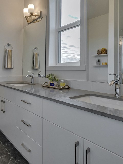 a large white kitchen with two sinks and a window
