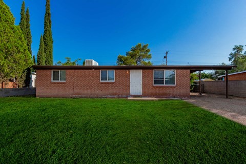 a brick house with a lawn in front of it
