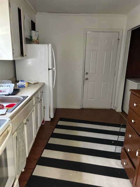 a small kitchen with a rug in the middle of the floor