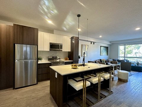 A modern kitchen with a large island and stainless steel appliances.