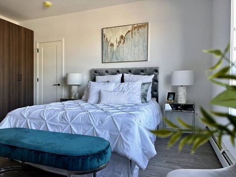 A bedroom with a large bed and a painting on the wall.