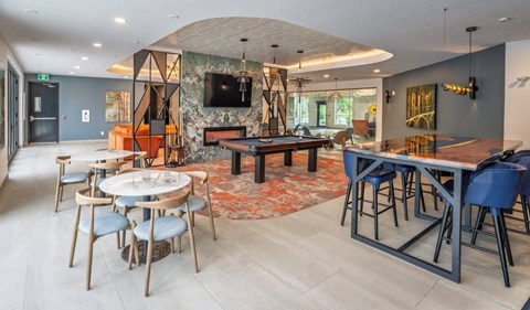 A modern dining area with a TV mounted on the wall and a fireplace.
