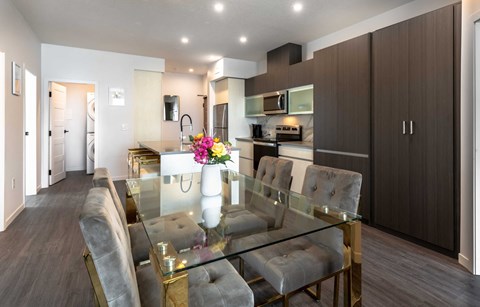 a dining room and kitchen with a glass table and chairs