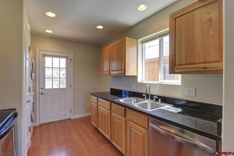 A kitchen with wooden cabinets and a black counter top.