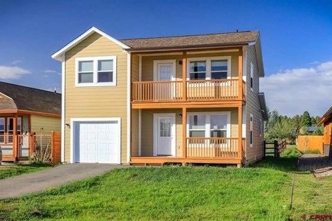 A two-story house with a balcony and a garage.