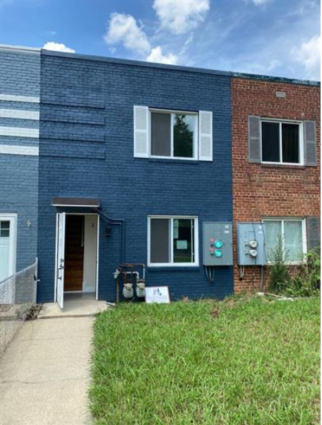 a blue building with a sidewalk in front of it