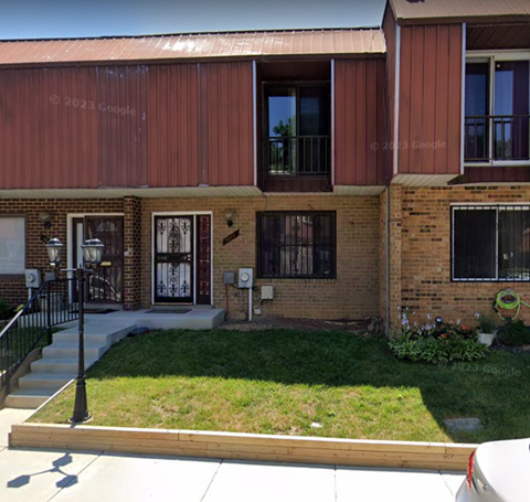 a brick building with a yard in front of it