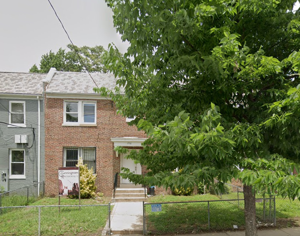 a brick house with a tree in front of it