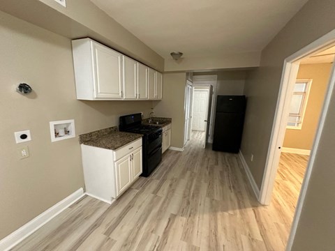 a kitchen with white cabinets and a black stove