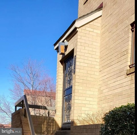 a brick building with a barred window and stairs
