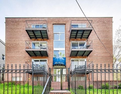 a brick building with three balconies and a gate