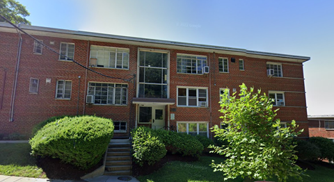 the front of a red brick building with stairs