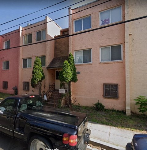 a black truck parked in front of an apartment building
