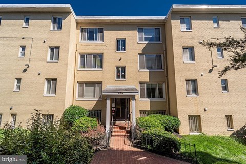 a large brick apartment building with a walkway in front