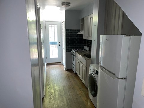 an empty kitchen with a washer and dryer in it